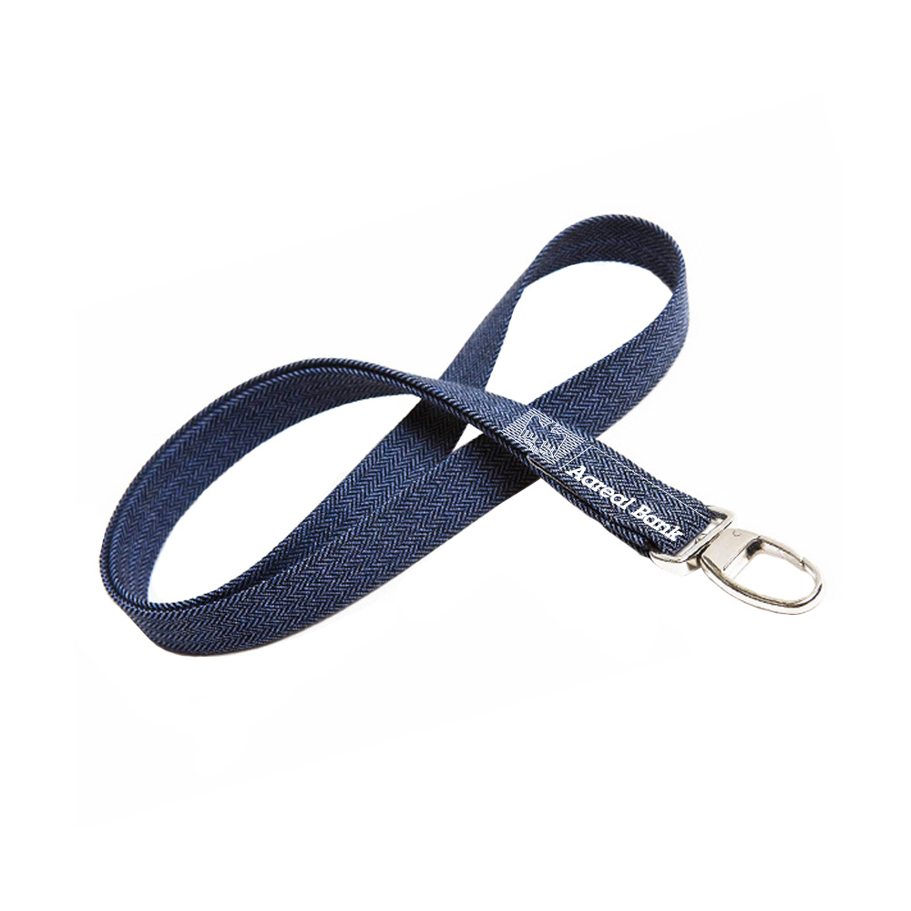 Ein blaues Schlüsselband aus Stoff mit Fischgrätenmuster und silbernem Metallverschluss, aufgerollt auf weißem Hintergrund – perfekt für Veranstaltungen bei der Vollblut Aareal Bank.