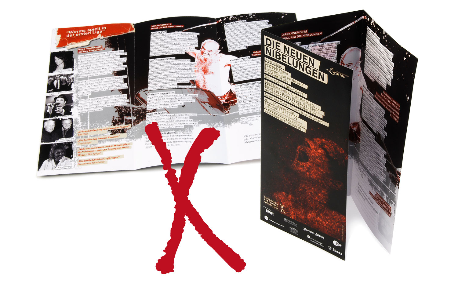 Eine dunkelfarbige Broschüre mit dem Titel DIE NEUEN NIBELUNGEN liegt aufgeschlagen neben einer vollständig aufgefalteten Version mit Texten und Bildern der Vollblut Nibelungen Festspiele. Über die aufgefaltete Broschüre ist ein großes rotes X gemalt.