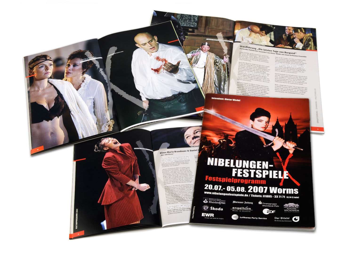 Es werden vier offene und ein geschlossenes Magazin mit dramatischen Theaterszenen und Artikeln gezeigt. Das Cover präsentiert die Vollblut Nibelungen Festspiele 2007 in Worms mit prägnanten Grafiken und Veranstaltungsdetails.