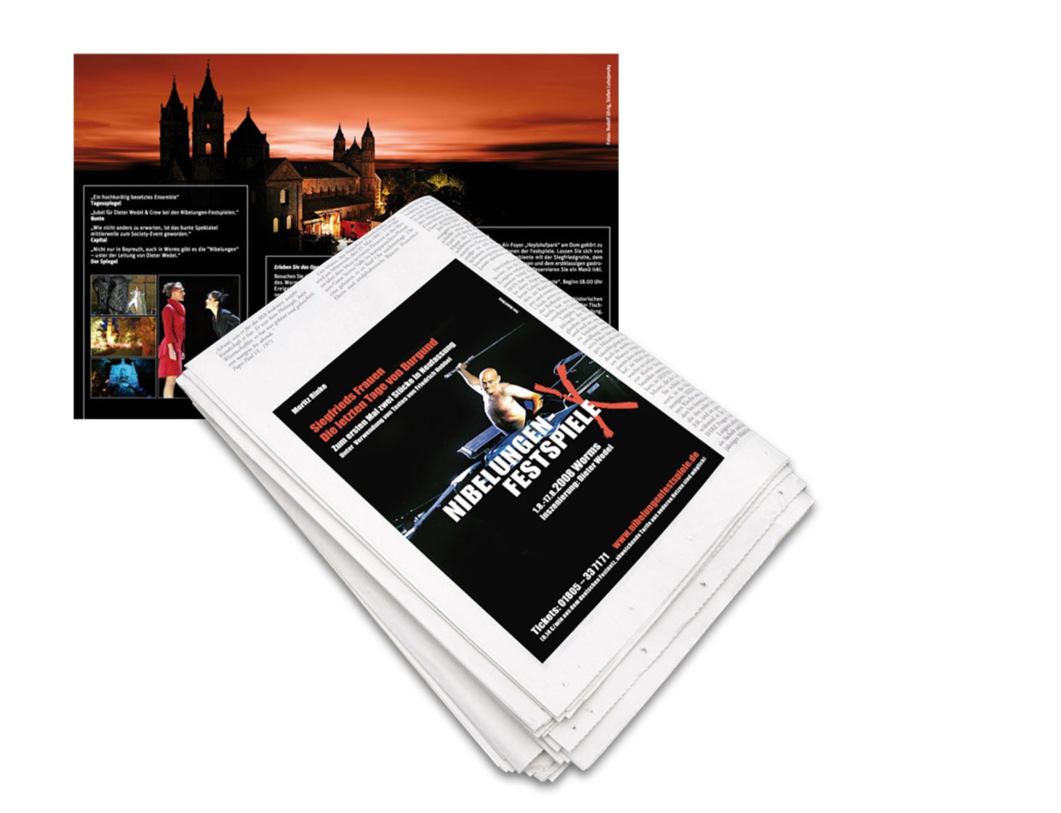 Ein Stapel Zeitungen mit einer sichtbaren Anzeige der Vollblut-Nibelungen-Festspiele, auf der ein Boxer abgebildet ist. Im Hintergrund zeigt eine aufgeschlagene Zeitschrift das Bild eines Schlosses bei Sonnenuntergang und Menschen in Kostümen.