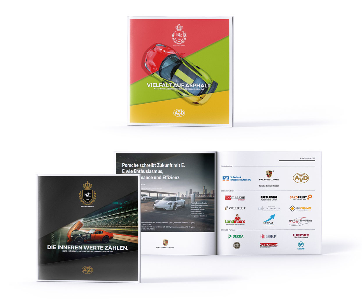Zwei Auto-Broschüren mit farbenfrohen Covern werden ausgestellt. Eine zeigt einen roten Sportwagen auf diagonalem grün-gelbem Hintergrund, die andere die Logos von Vollblut und KSAC in einer Tunnelszene. Aufgeschlagene Broschüren zeigen Autobilder und AvD-Sponsorenlogos.